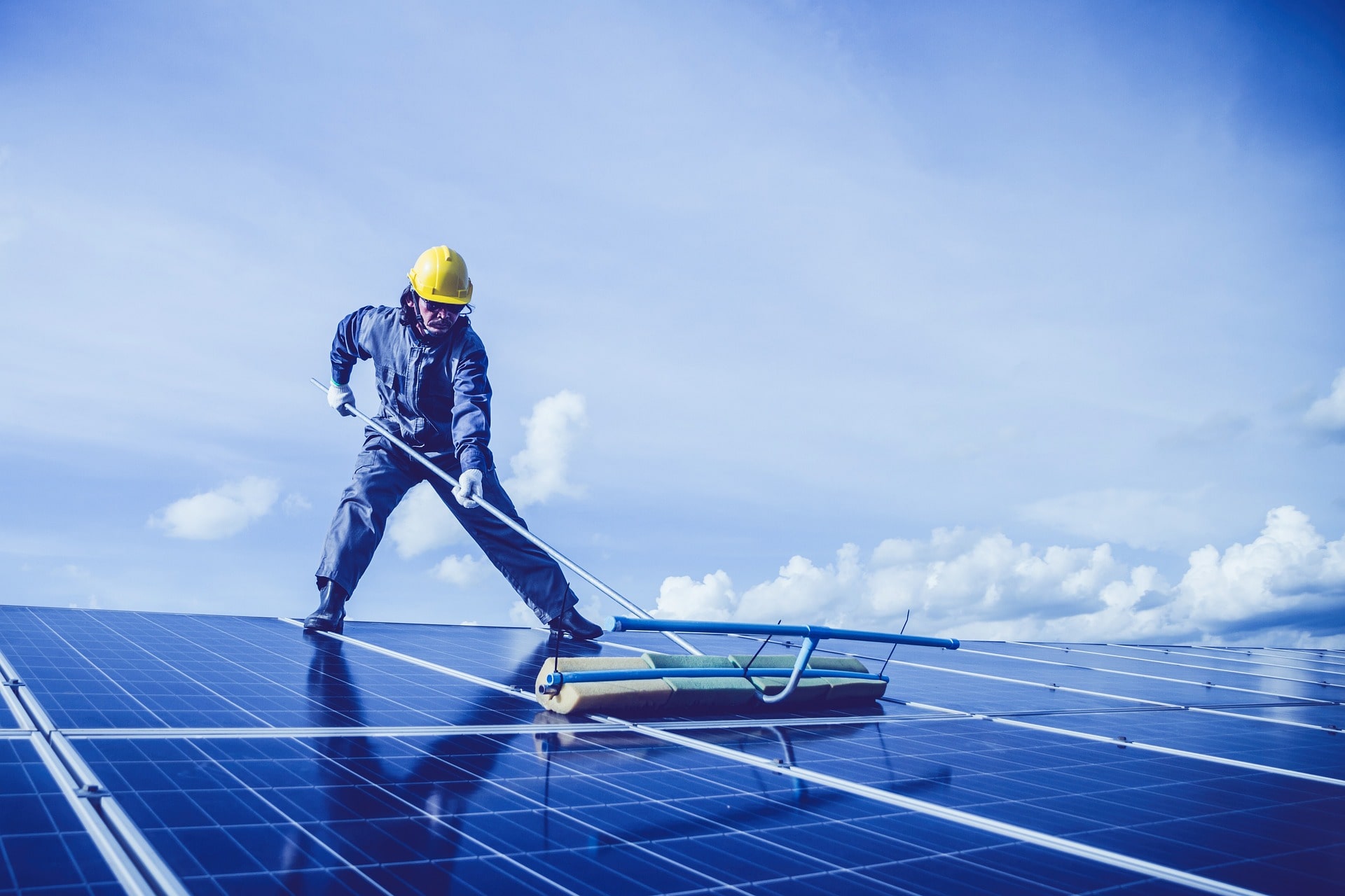 A professional solar installer on a roof installing solar panels, building a reliable and energy-efficient solar system.