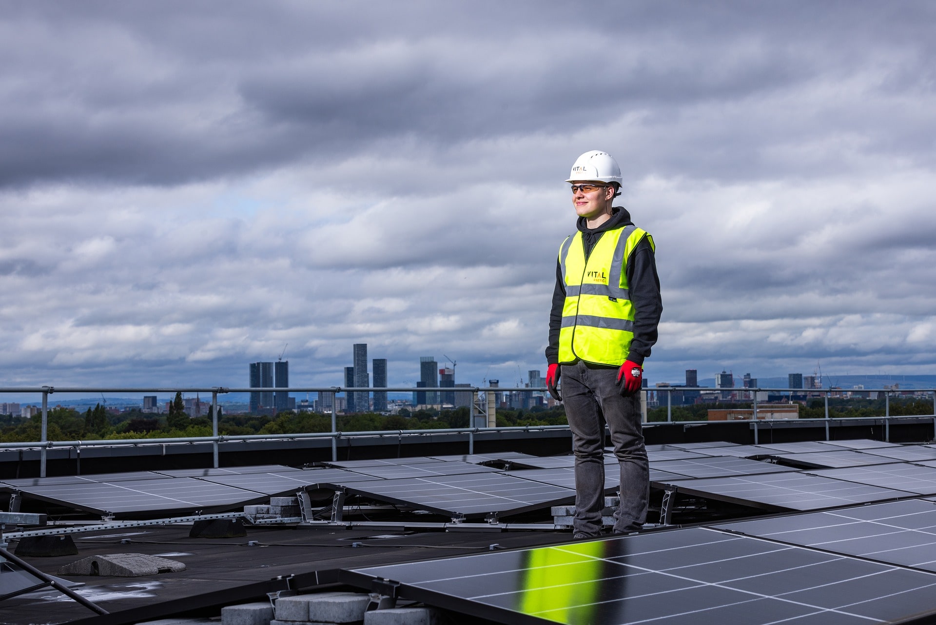 A man standing and observing a vast field of solar panels, representing the potential of an expansive solar system built through expert solar installations.