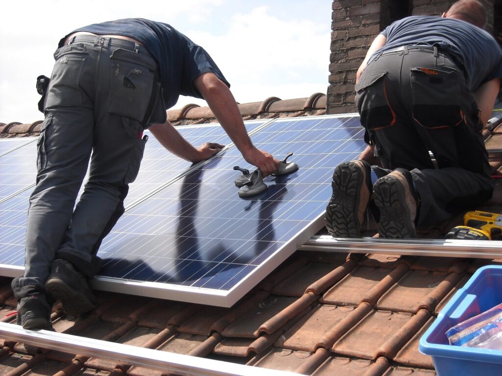 A team of professional solar installers on a roof installing solar panels, building a reliable and energy-efficient solar system.